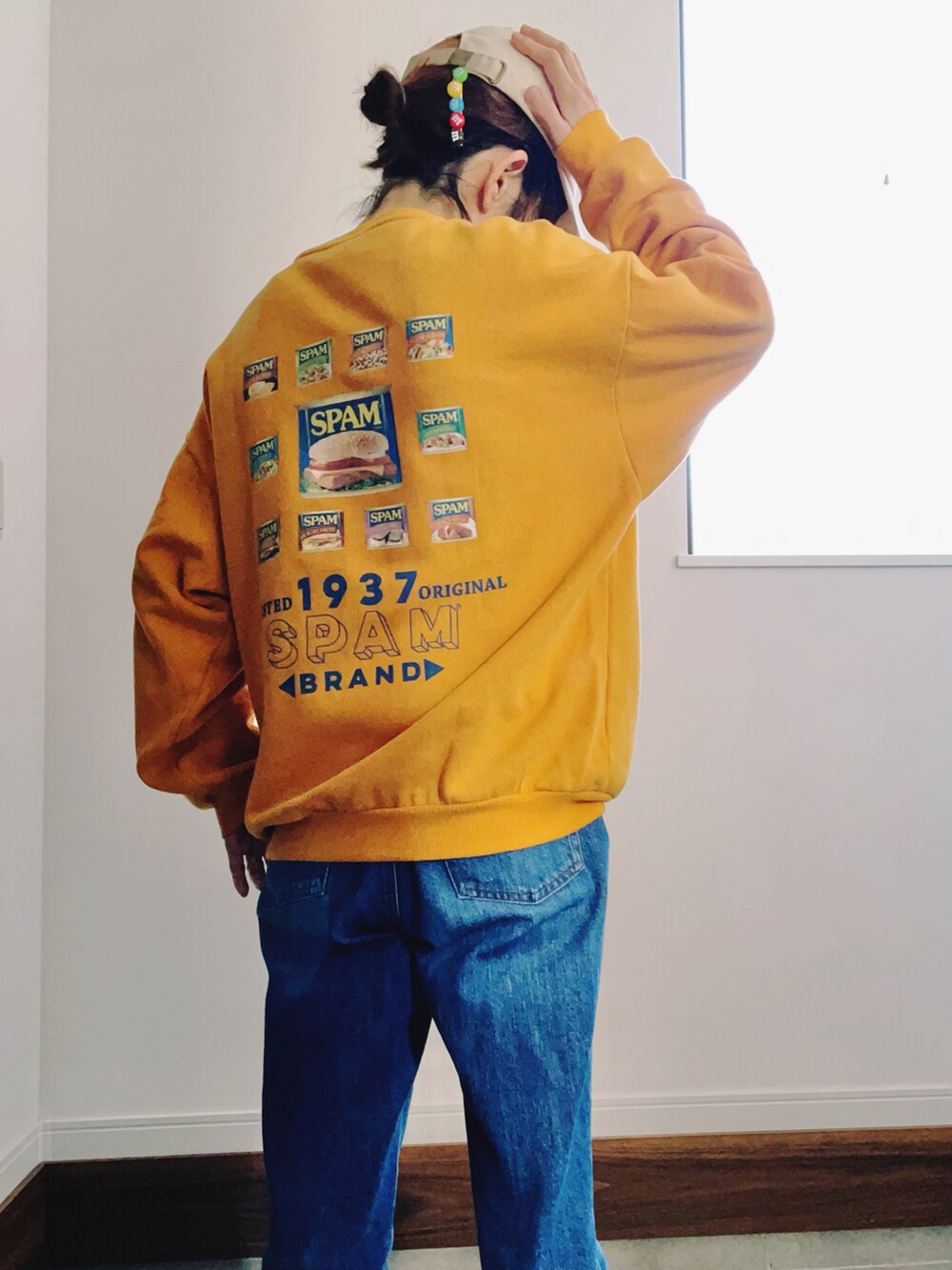 ブルー系のデニムパンツ、ホワイト系のスニーカー、イエロー系のスウェットを着用したレディースの冬コーディネートの3枚目の写真