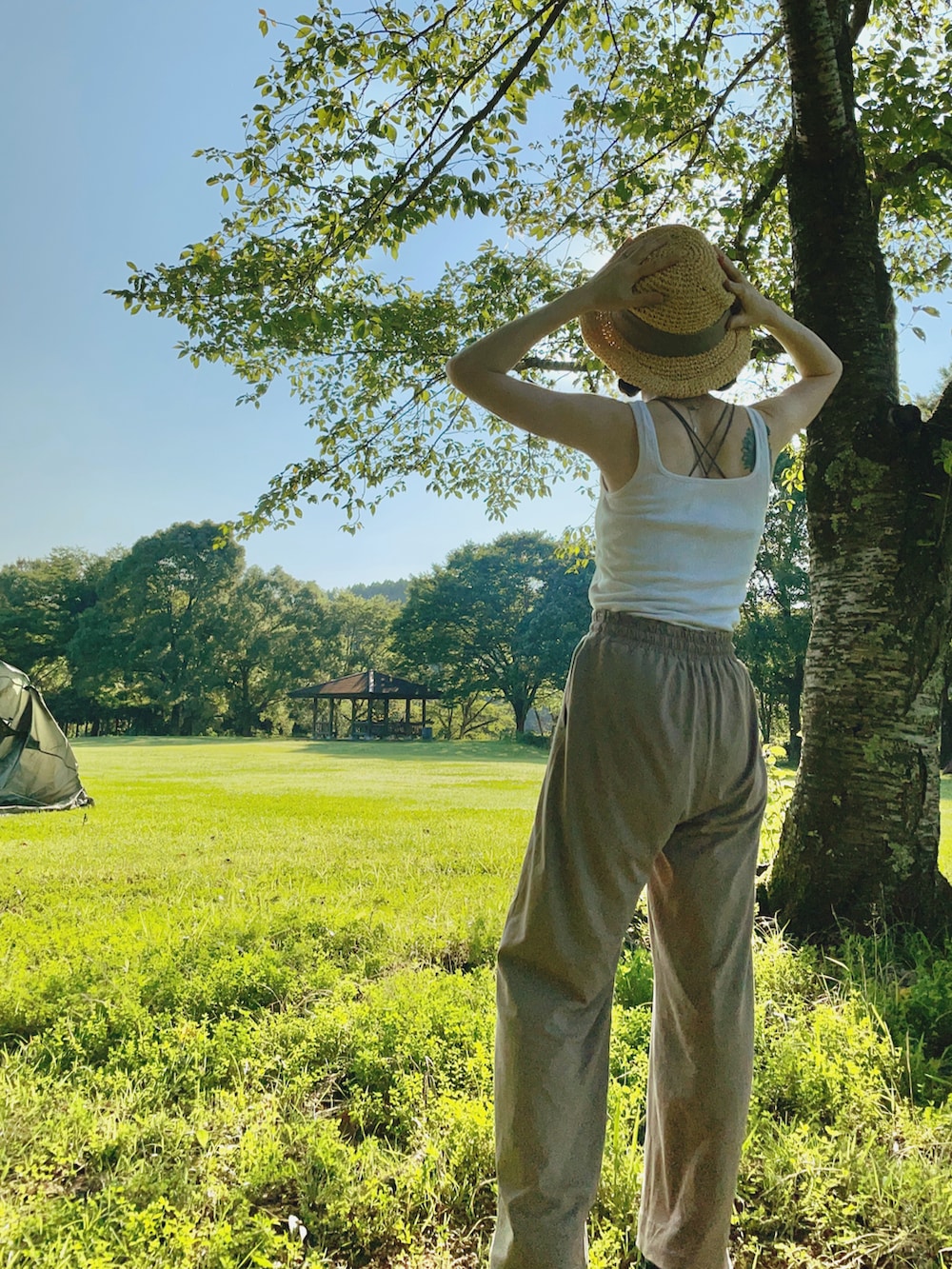 ホワイト系のタンクトップ、ブラウン系のキャミソール、ブラウン系のその他パンツを着用したレディースの夏コーディネートの2枚目の写真