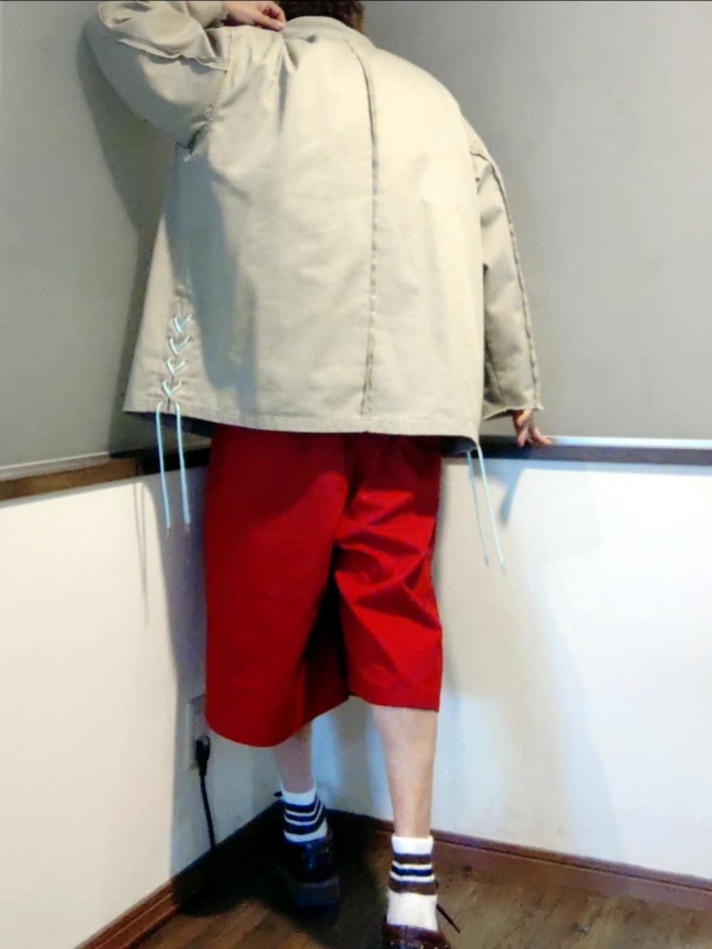 ベージュ系のカバーオール、レッド系のチノパンツ、ブラウン系のモカシン/デッキシューズを着用したメンズの春コーディネートの4枚目の写真