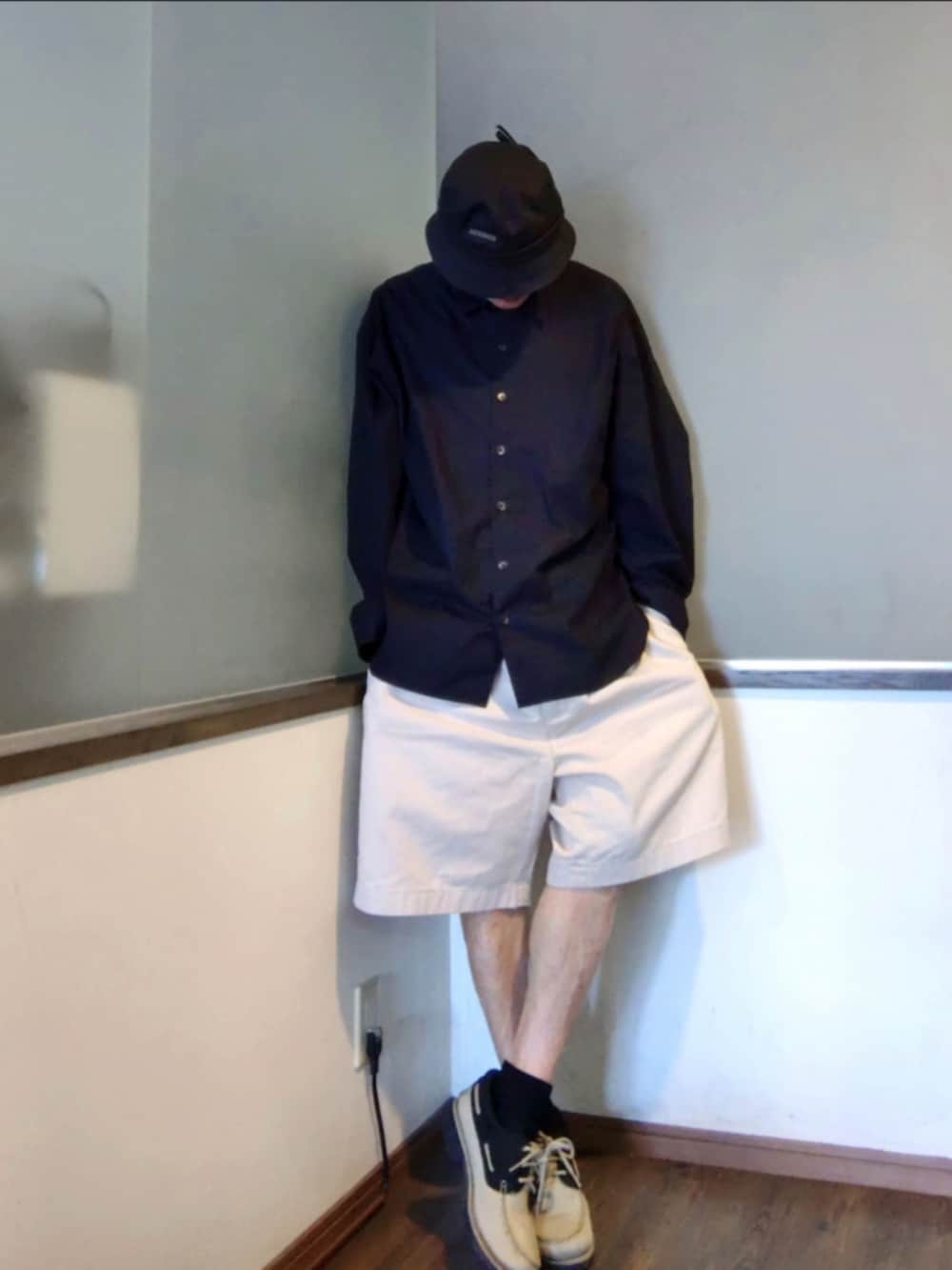 ブラック系のシャツ/ブラウス、ベージュ系のチノパンツ、ブラウン系のモカシン/デッキシューズを着用したメンズの夏コーディネートの2枚目の写真