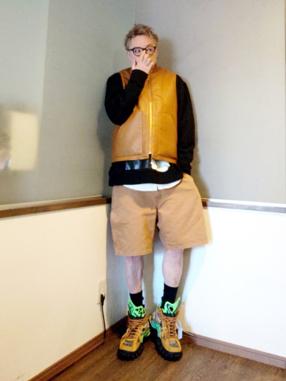 ブラウン系のパンツ、ブラウン系のダウンベスト、ブラック系のスウェットを着用したメンズの春コーディネートの3枚目の写真