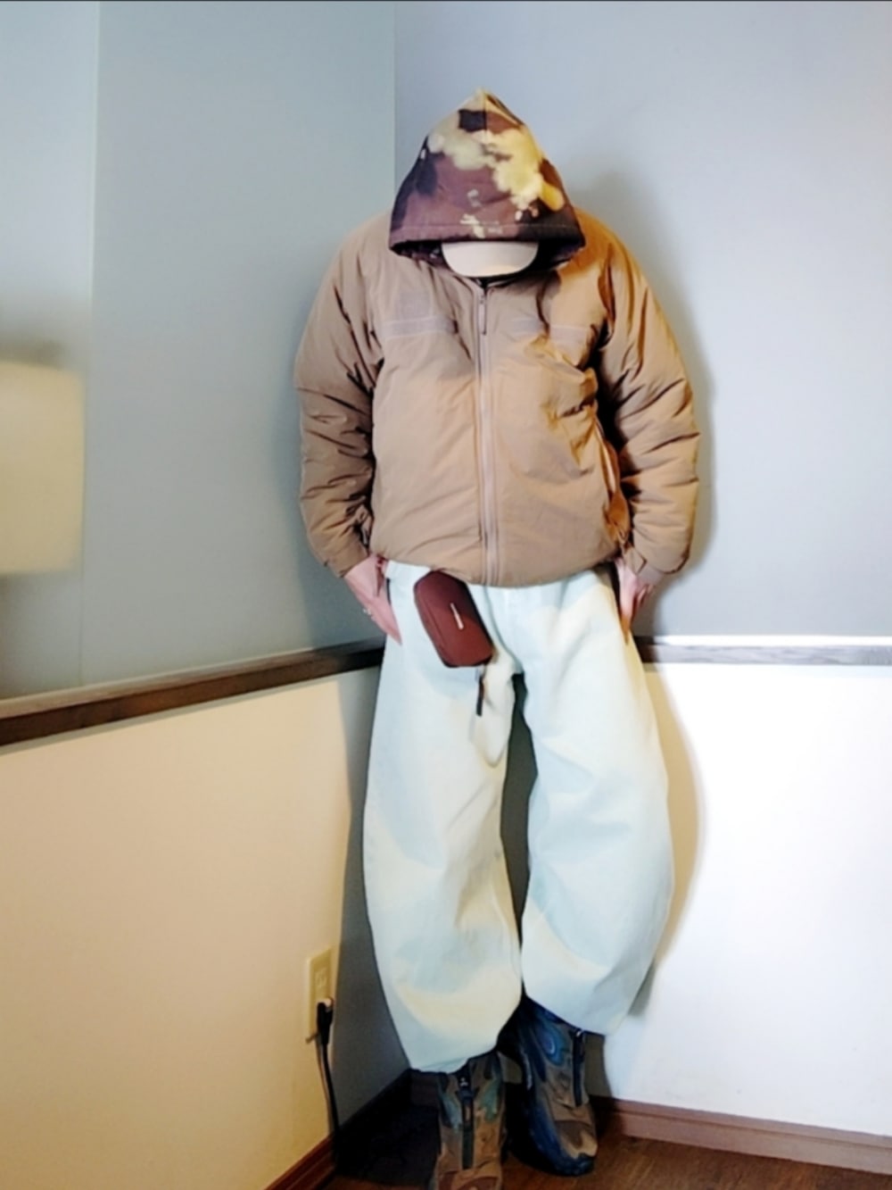 ベージュ系のダウンジャケット/コート、ブラック系のパーカー、ブルー系のデニムパンツを着用したメンズの冬コーディネートの4枚目の写真