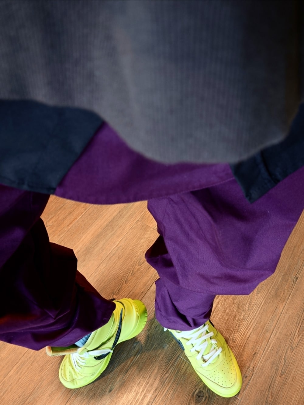 グリーン系のスニーカー、パープル系のカーゴパンツ、ブラック系のMA-1を着用したメンズの秋コーディネートの3枚目の写真