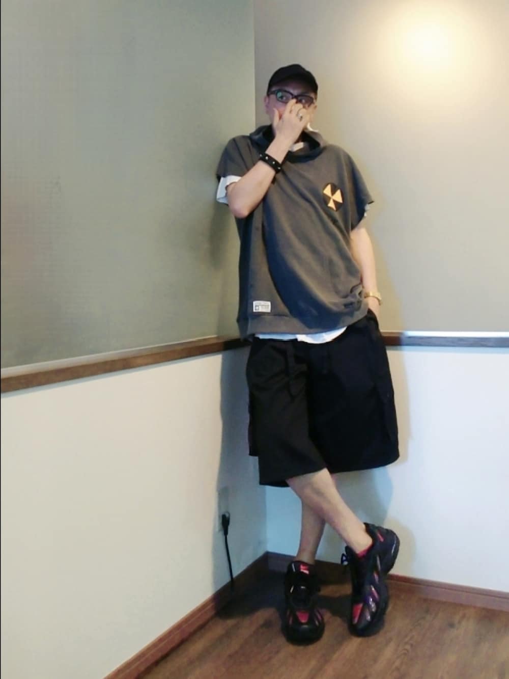 グレー系のパーカー、ブラック系のカーゴパンツ、ブラック系のスニーカーを着用したメンズの夏コーディネートの3枚目の写真