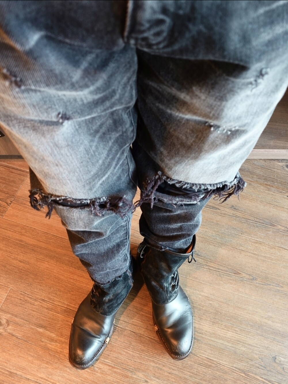 ベージュ系のチェスターコート、ブラック系のデニムパンツ、ブラック系のブーツを着用したメンズの秋コーディネートの3枚目の写真