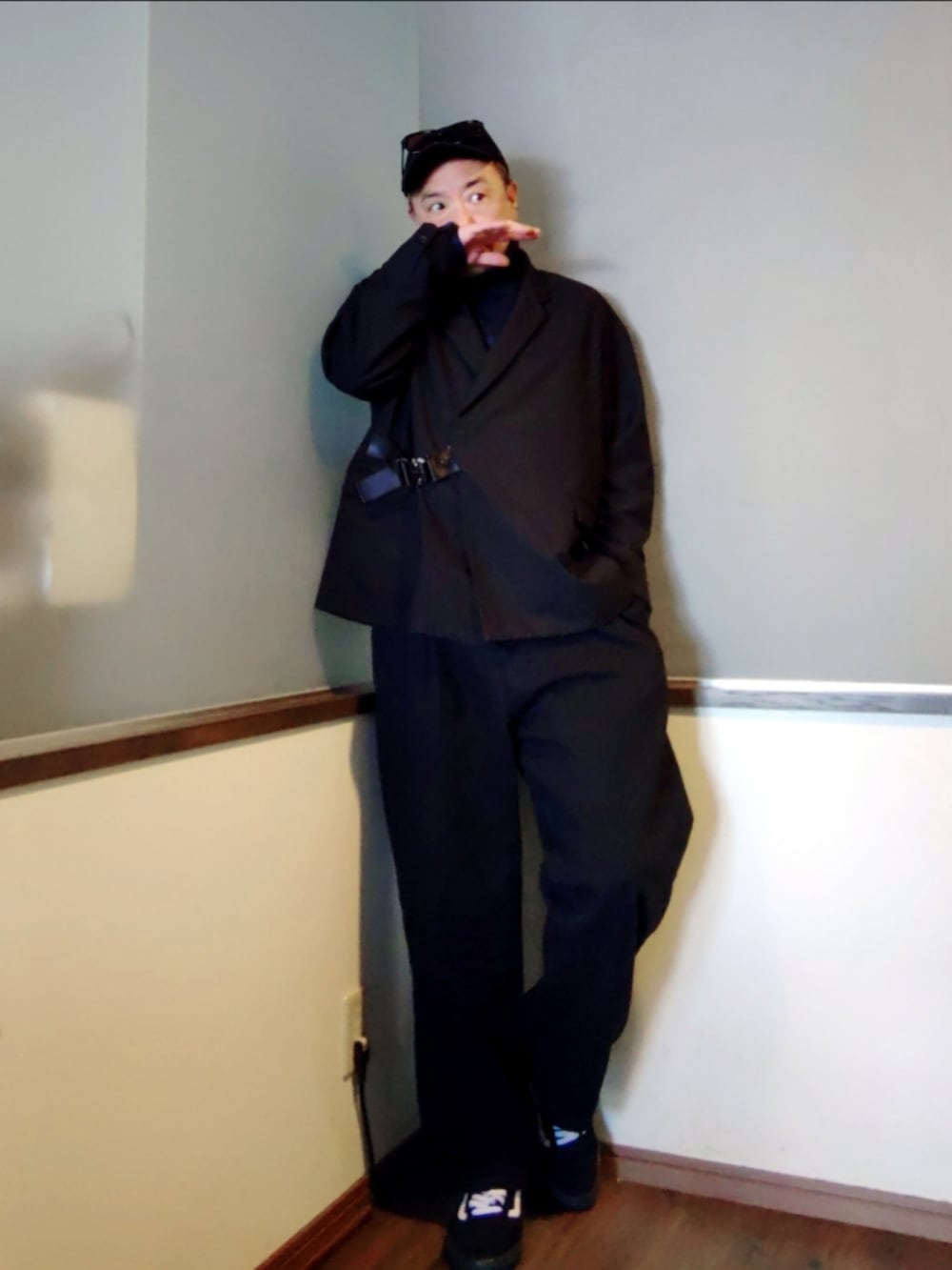 ブルー系のモッズコート、ブラック系のショルダーバッグ、ブラック系のスニーカーを着用したメンズの春コーディネートの2枚目の写真