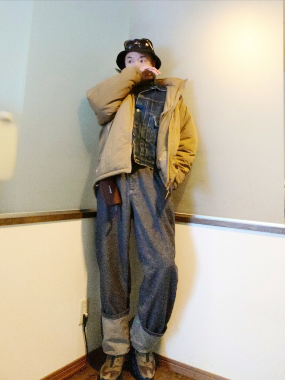 ブルー系のデニムジャケット、ベージュ系のダウンジャケット/コート、ブルー系のデニムパンツを着用したメンズの冬コーディネートの2枚目の写真