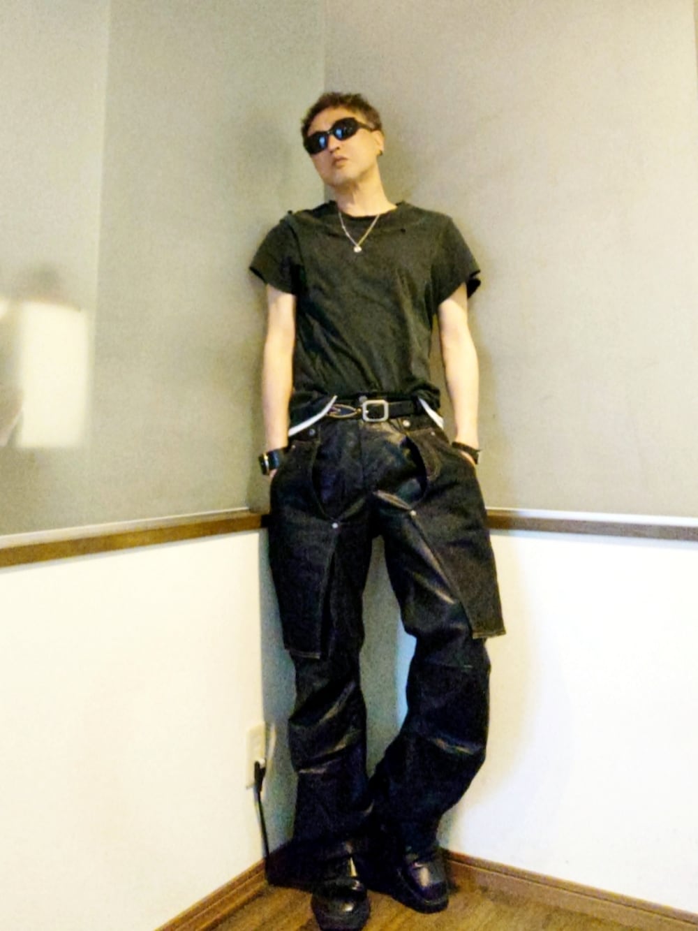 ブラック系のTシャツ/カットソー、ブルー系のデニムパンツ、ブラック系のドレスシューズを着用したメンズの春コーディネートの2枚目の写真