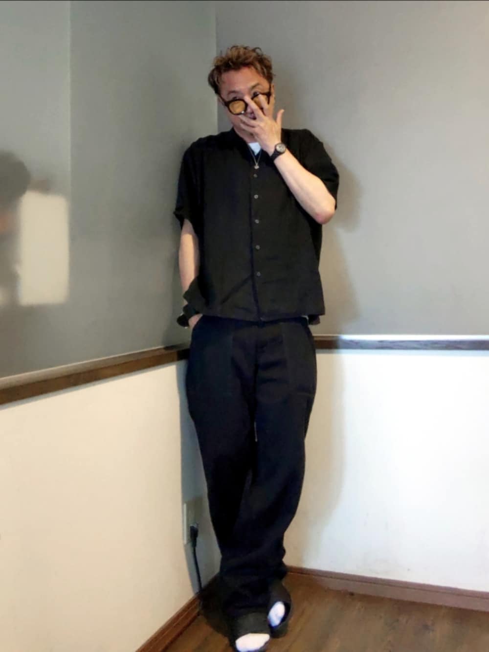 ブラック系のシャツ/ブラウス、ブラック系のチノパンツ、ブラック系のサンダルを着用したメンズの夏コーディネートの2枚目の写真