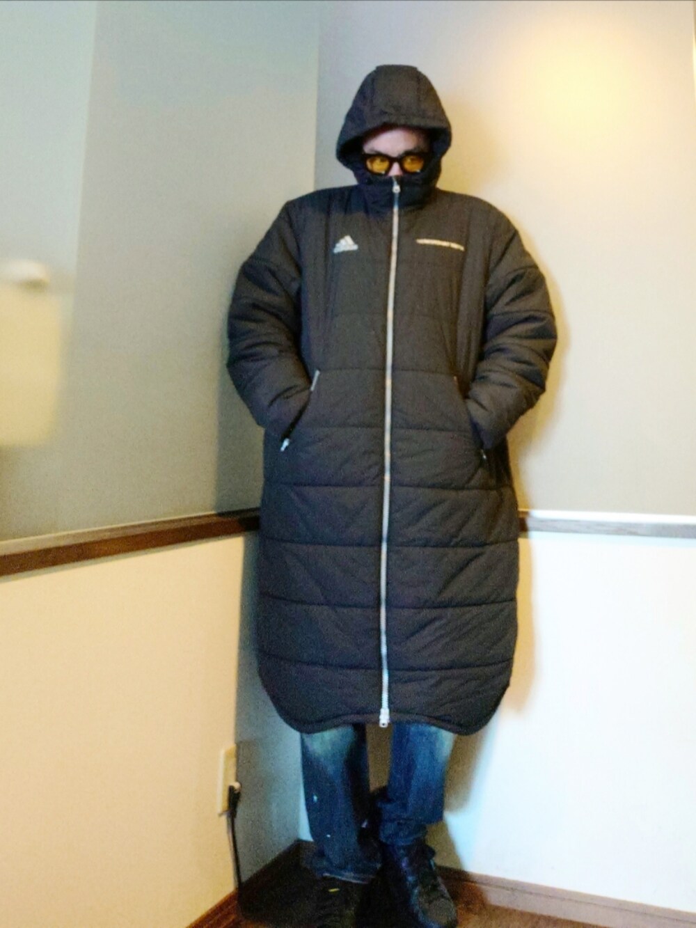 ブラック系のダウンジャケット/コート、ブルー系のデニムパンツ、ブラック系のスニーカーを着用したメンズの冬コーディネートの3枚目の写真