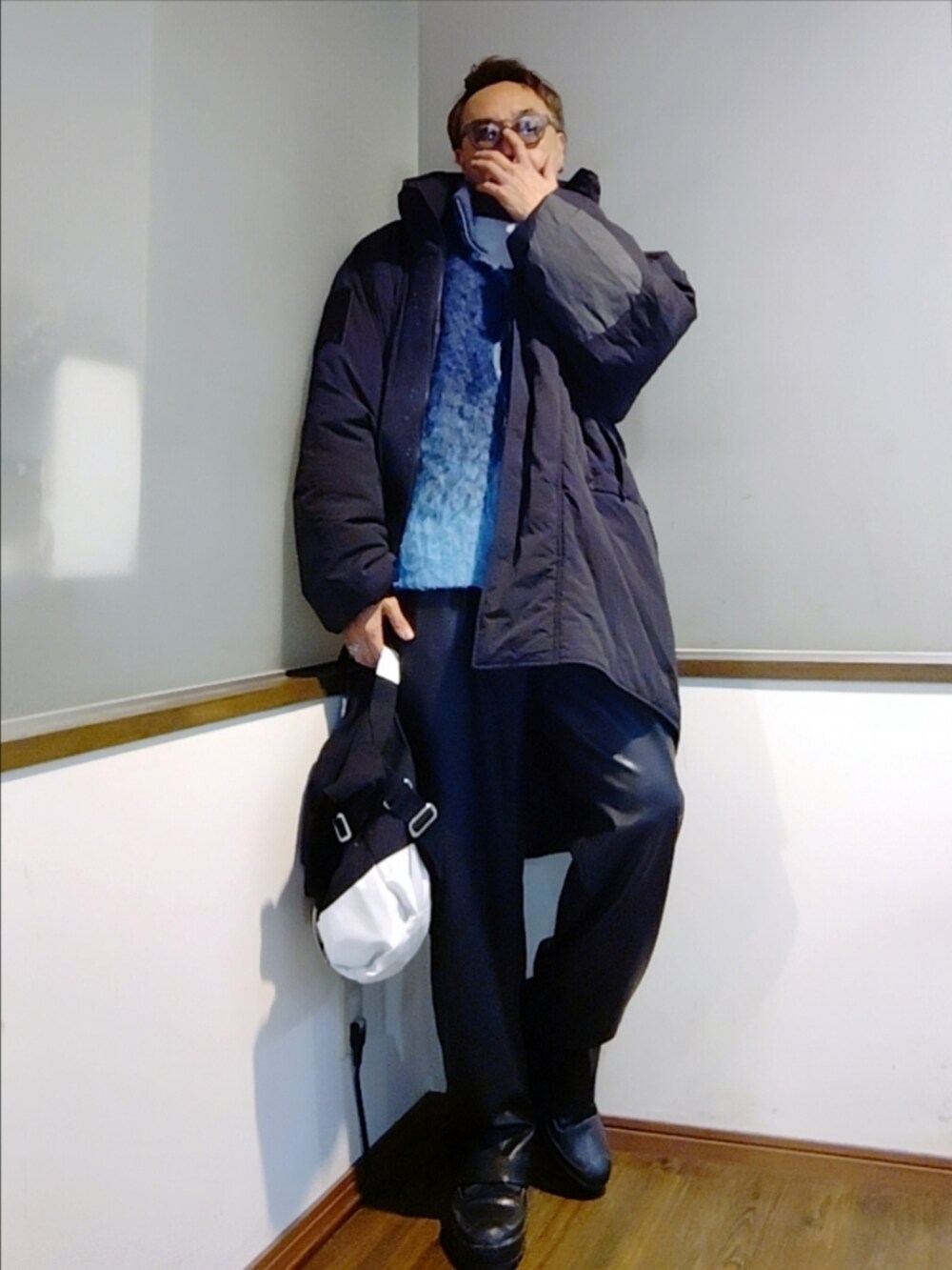 ブルー系のニット/セーター、ブラック系のダウンジャケット/コート、ブラック系のその他パンツを着用したメンズの冬コーディネートの2枚目の写真