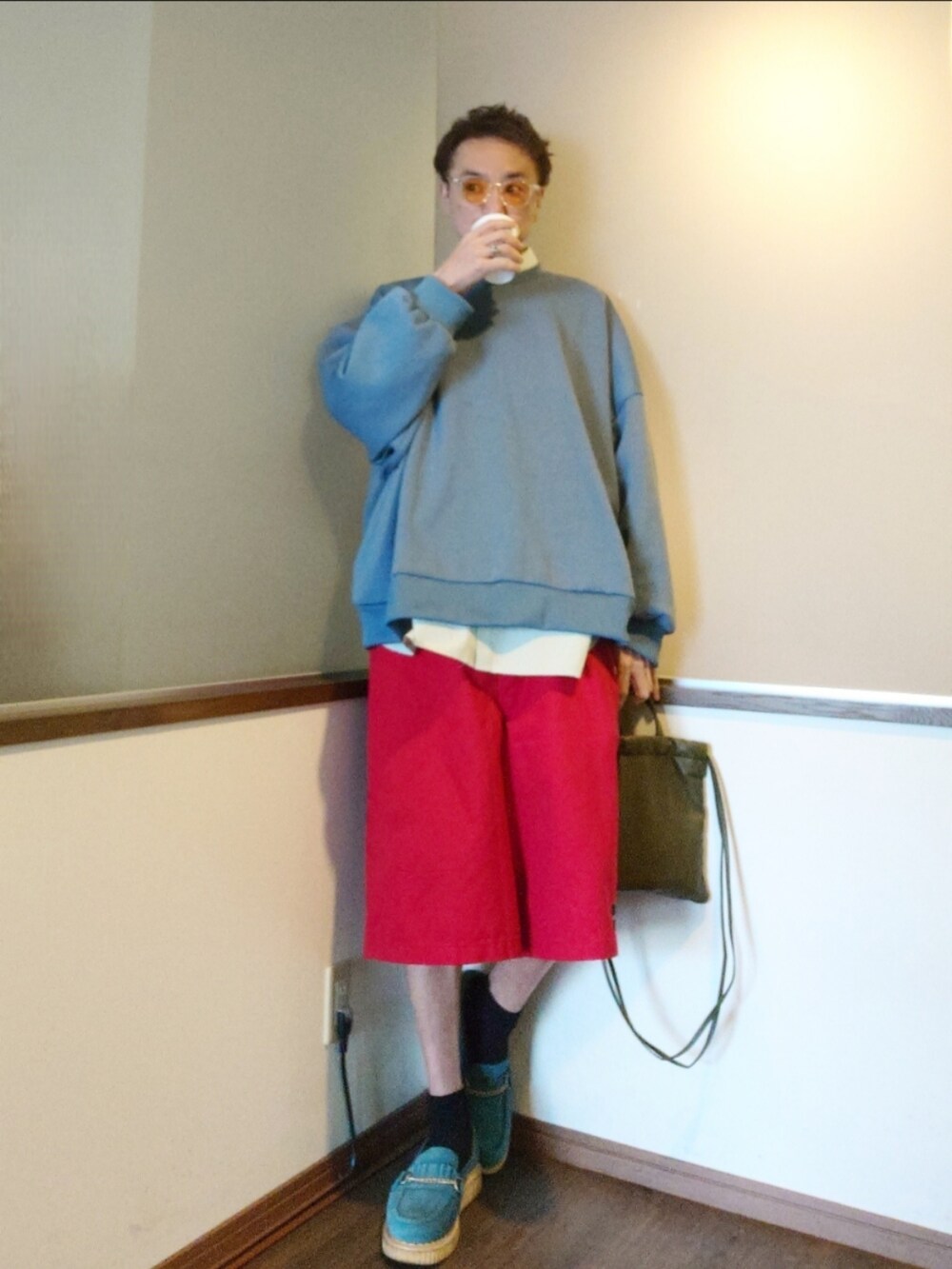 レッド系のチノパンツ、グリーン系のショルダーバッグ、ブルー系のローファーを着用したメンズの春コーディネートの2枚目の写真