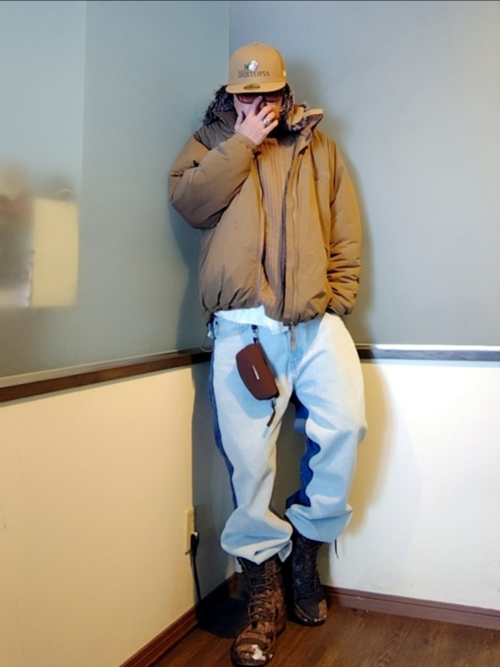 ベージュ系のダウンジャケット/コート、ブルー系のデニムパンツ、ブラウン系のブーツを着用したメンズの冬コーディネートの2枚目の写真