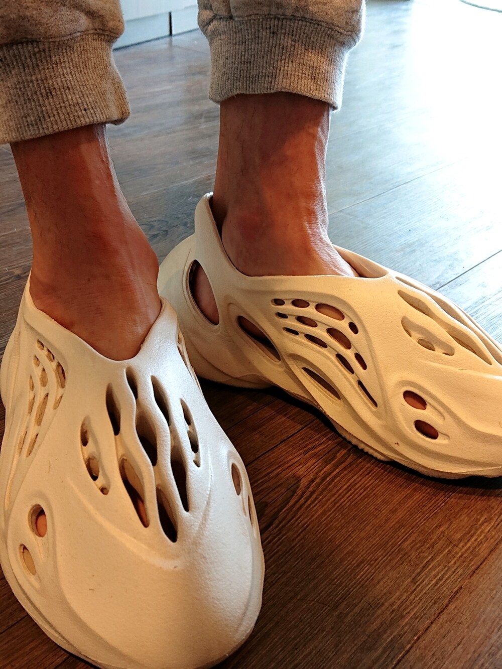 レッド系のTシャツ/カットソー、グレー系のスウェットパンツ、ホワイト系のスニーカーを着用したメンズの夏コーディネートの4枚目の写真