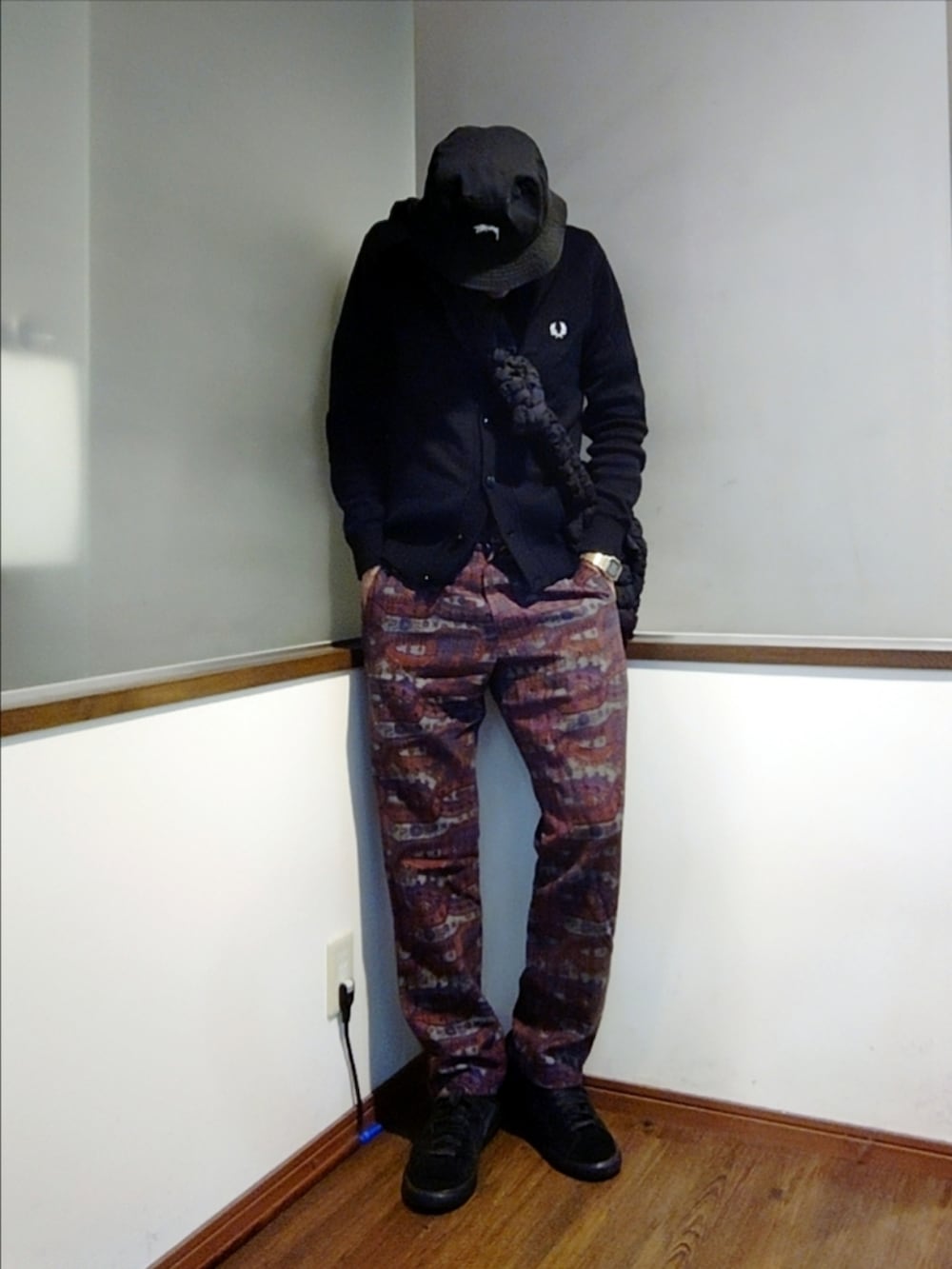 ブラック系のカーディガン/ボレロ、レッド系のパンツ、ブラック系のスニーカーを着用したメンズの秋コーディネートの2枚目の写真