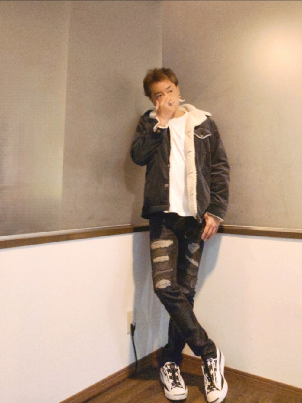 グレー系のブルゾン、ブラック系のデニムパンツ、ホワイト系のスニーカーを着用したメンズの秋コーディネートの3枚目の写真