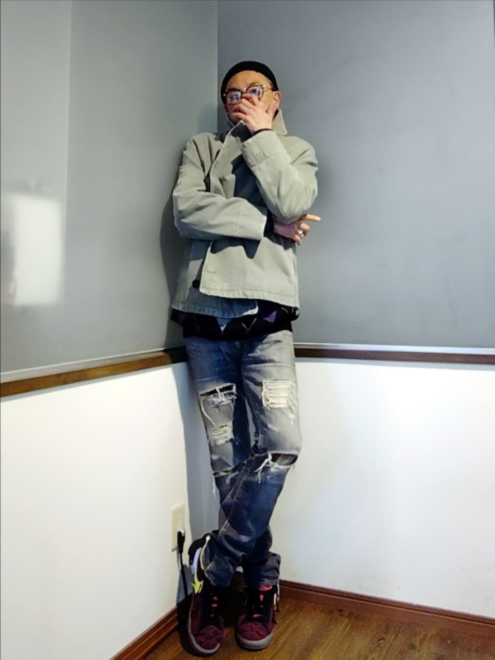 ブラック系のニット/セーター、ブラック系のデニムパンツ、レッド系のスニーカーを着用したメンズの秋コーディネートの3枚目の写真