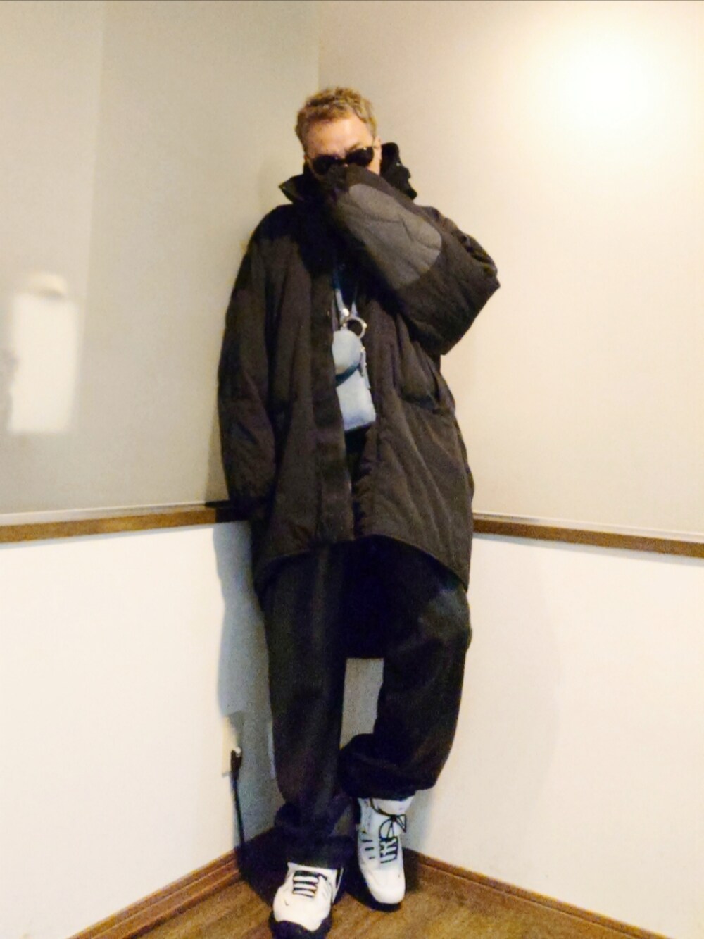 ブルー系のデニムジャケット、ブラック系のダウンジャケット/コート、ブルー系のショルダーバッグを着用したメンズの冬コーディネートの3枚目の写真