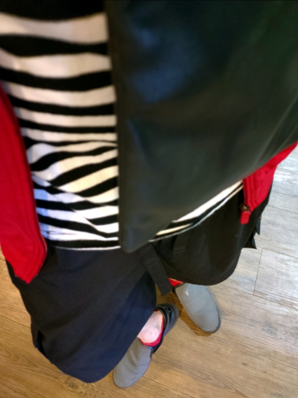 レッド系のジャージ、ブラック系のカーゴパンツ、グレー系のスニーカーを着用したメンズの秋コーディネートの2枚目の写真