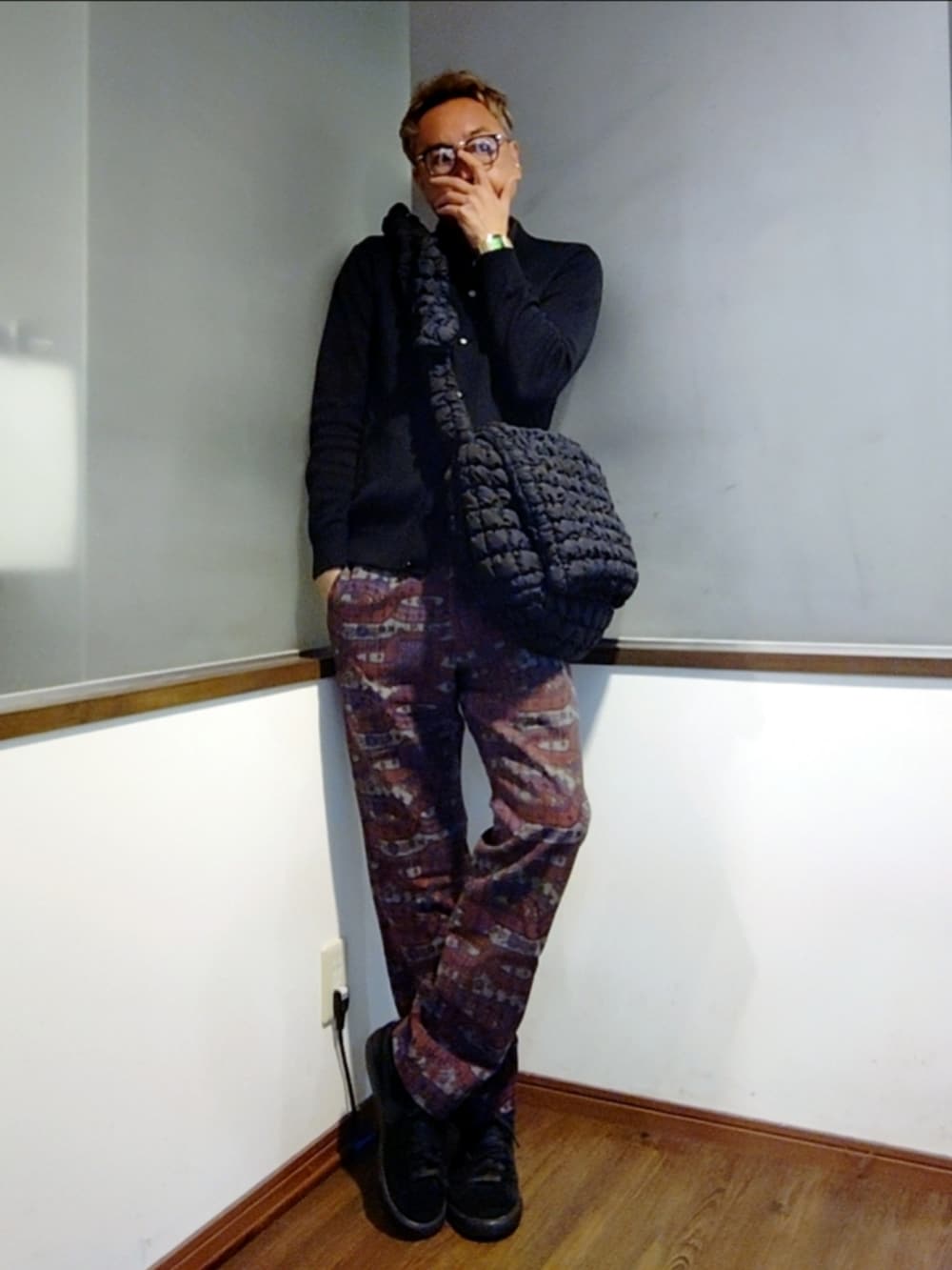 ブラック系のカーディガン/ボレロ、レッド系のパンツ、ブラック系のスニーカーを着用したメンズの秋コーディネートの3枚目の写真