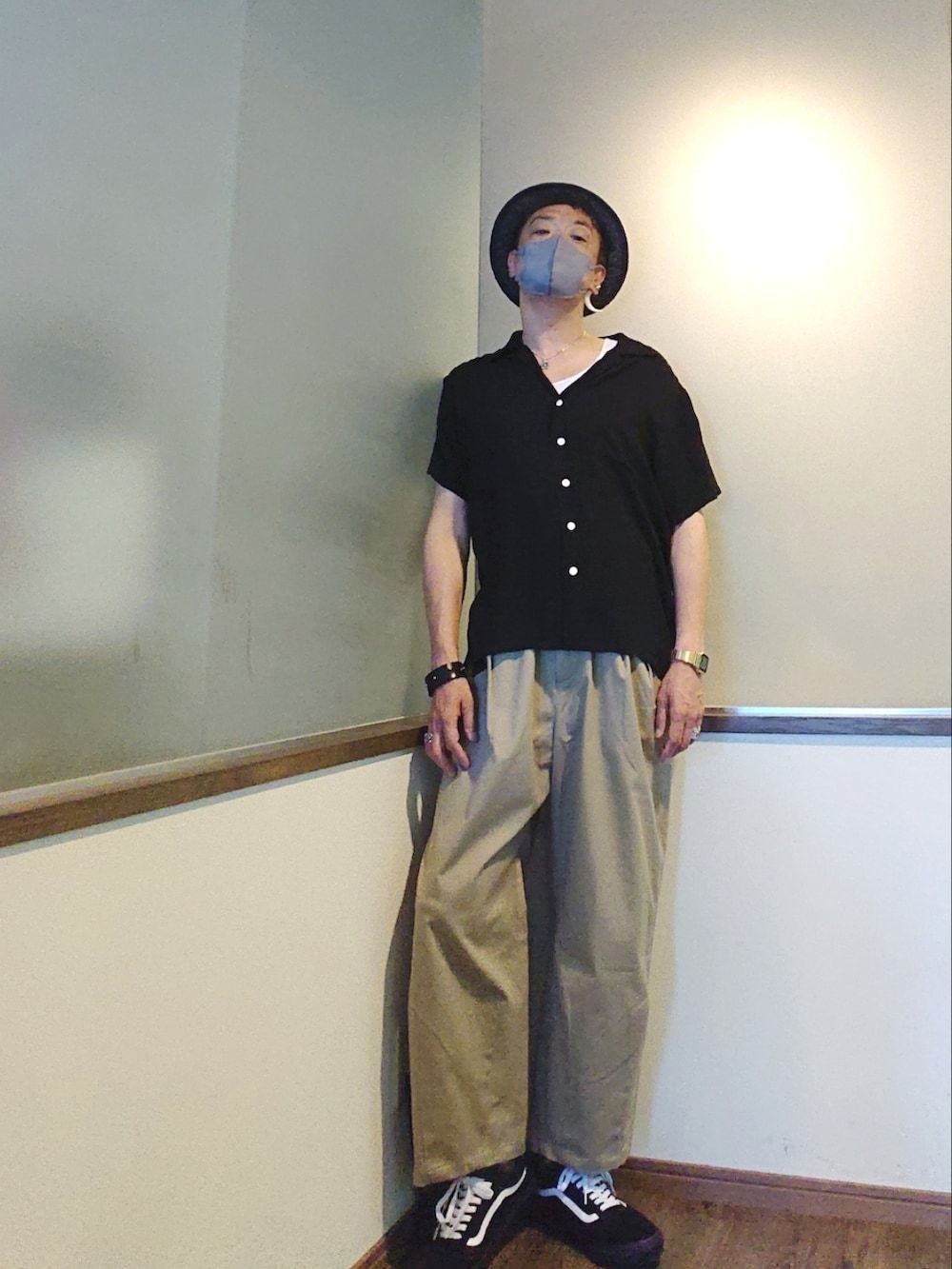 ベージュ系のチノパンツ、ブラック系のシャツ/ブラウス、ブラック系のスニーカーを着用したメンズの夏コーディネートの2枚目の写真