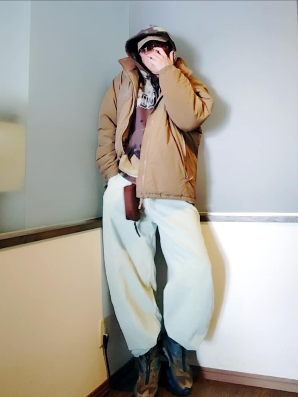 ベージュ系のダウンジャケット/コート、ブラック系のパーカー、ブルー系のデニムパンツを着用したメンズの冬コーディネートの2枚目の写真