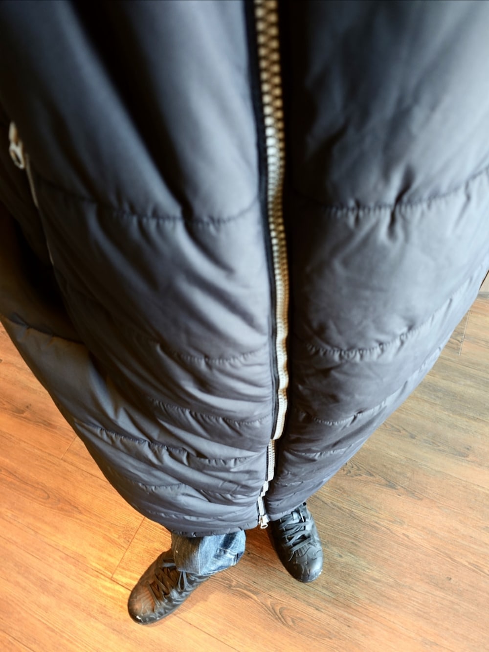 ブラック系のダウンジャケット/コート、ブルー系のデニムパンツ、ブラック系のスニーカーを着用したメンズの冬コーディネートの4枚目の写真