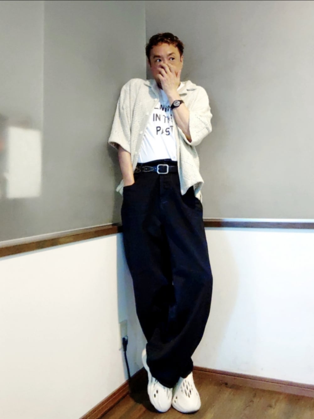 ベージュ系のシャツ/ブラウス、ブラック系のデニムパンツ、ホワイト系のスニーカーを着用したメンズの夏コーディネートの2枚目の写真