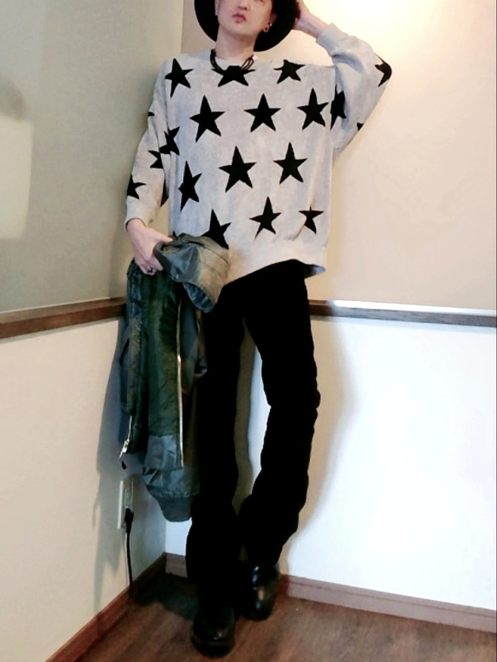 グリーン系のブルゾン、グレー系のニット/セーター、ブラック系のパンツを着用したメンズの春コーディネートの2枚目の写真