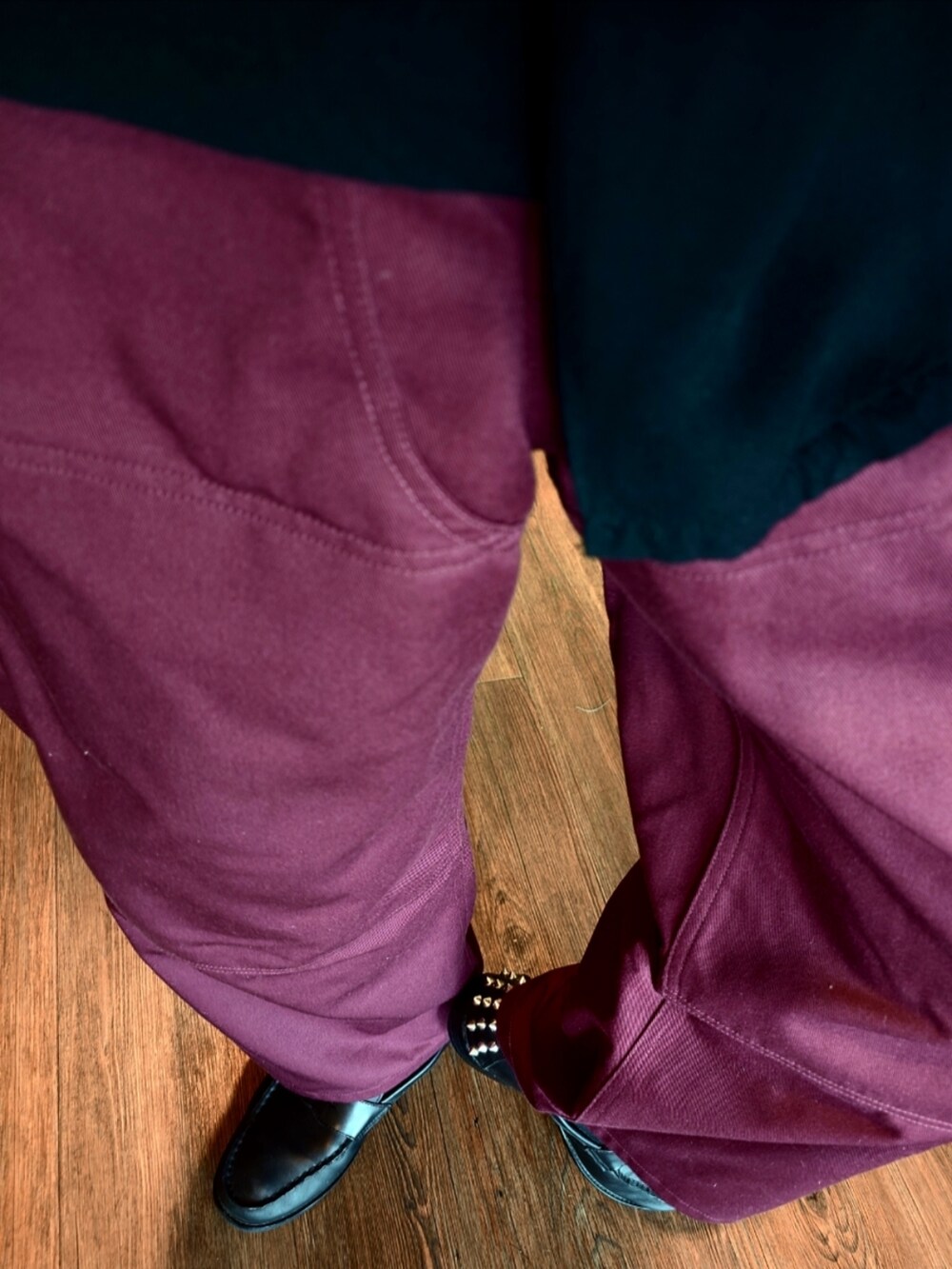 レッド系のパンツ、ブラック系のローファー、ブラック系のキャップを着用したメンズの夏コーディネートの2枚目の写真