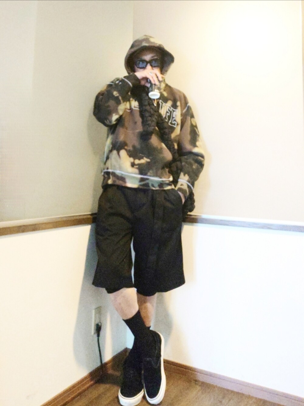 ブラック系のパーカー、ブラック系のチノパンツ、ブラック系のスニーカーを着用したメンズの秋コーディネートの2枚目の写真