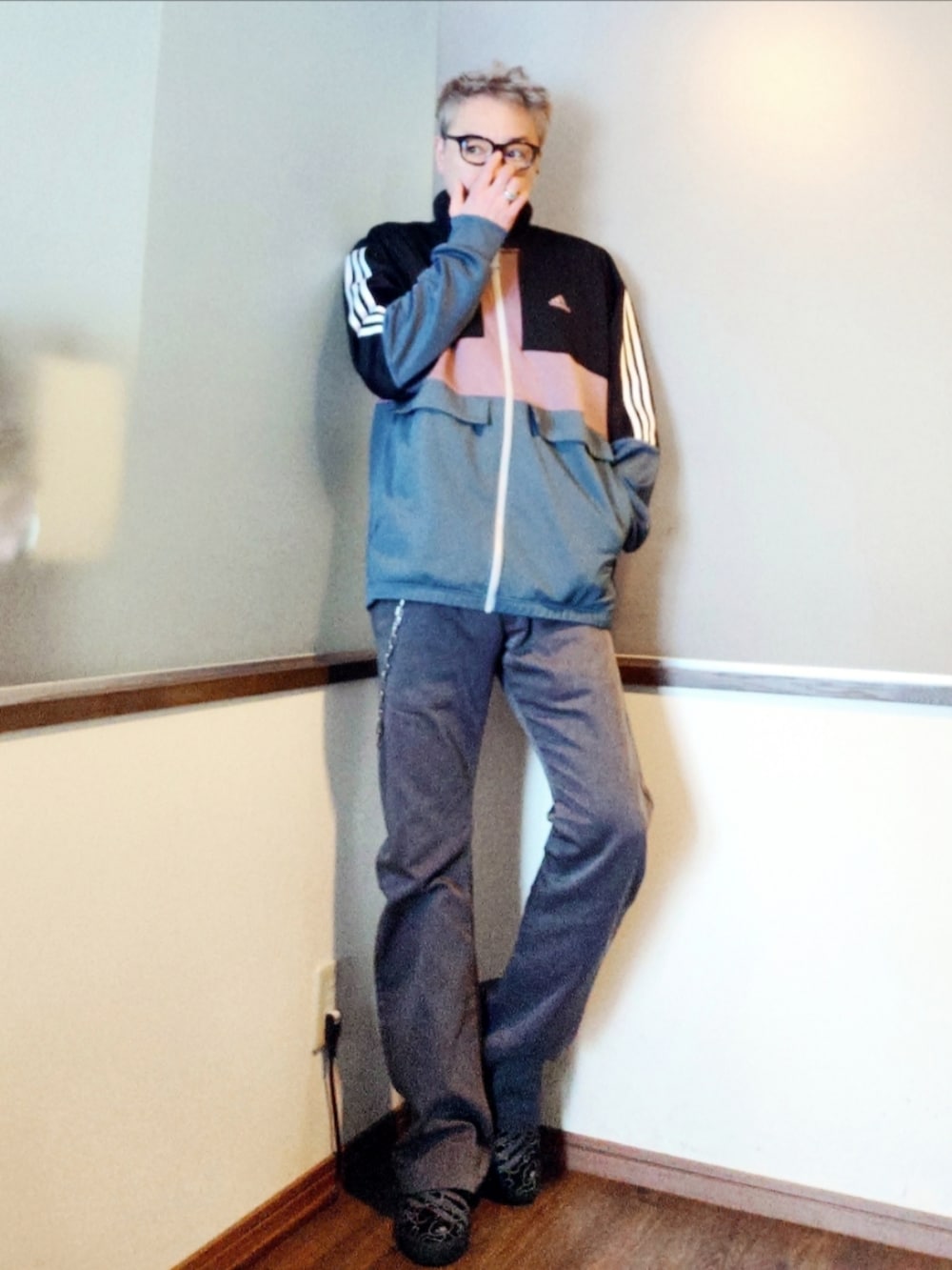 パープル系のナイロンジャケット、ブラック系のブルゾン、グレー系のチノパンツを着用したメンズの春コーディネートの2枚目の写真