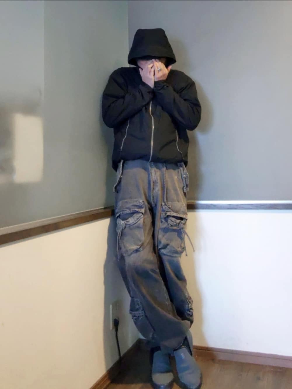 グレー系のニット/セーター、ブラック系のカーゴパンツ、グレー系のスニーカーを着用したメンズの春コーディネートの3枚目の写真