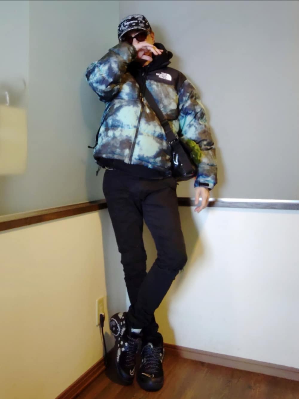 ブルー系のダウンジャケット/コート、ブラック系のパーカー、ブラック系のデニムパンツを着用したメンズの冬コーディネートの3枚目の写真