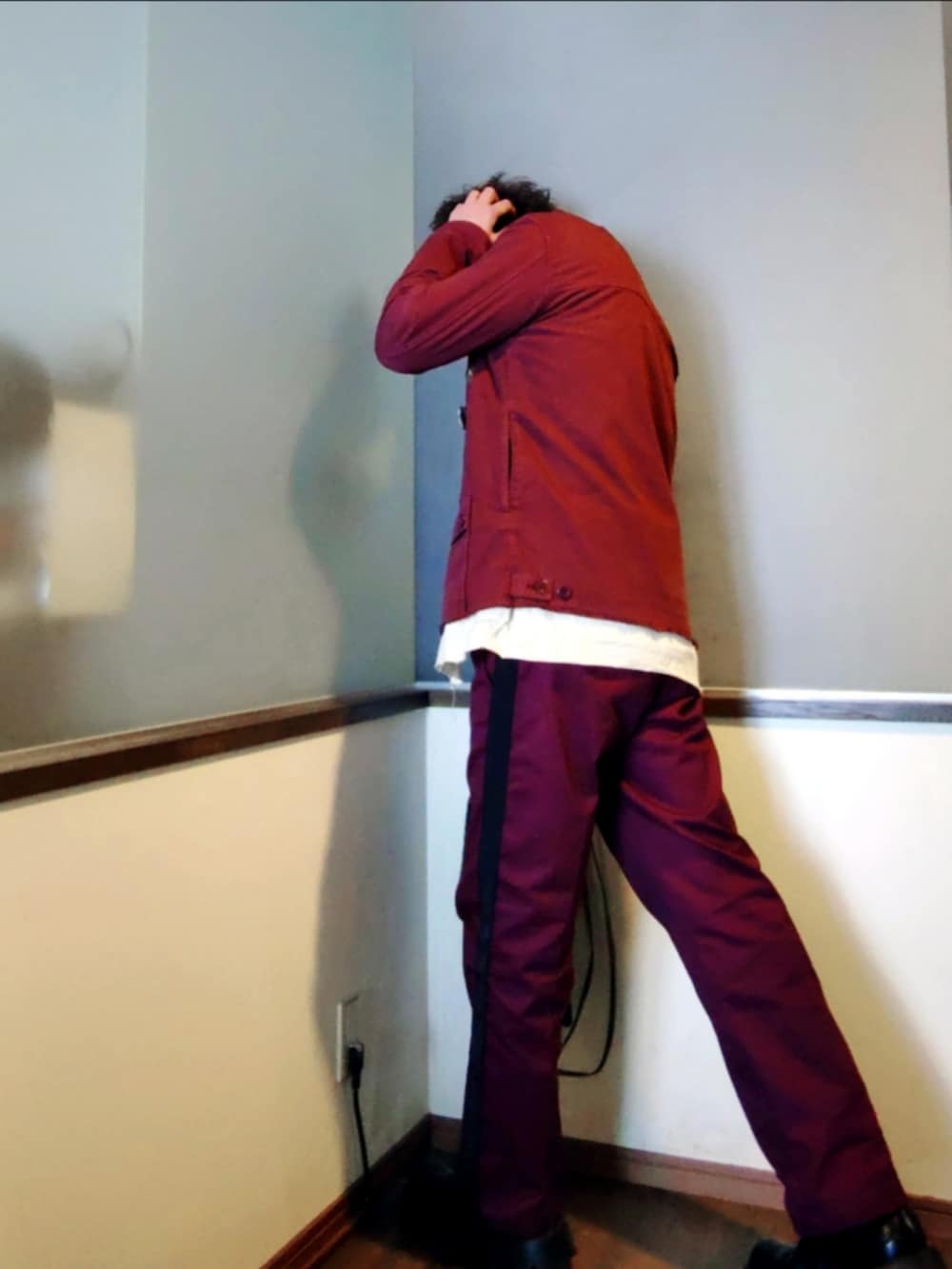 レッド系のチノパンツ、レッド系のカバーオール、ブラック系のカーディガン/ボレロを着用したメンズの春コーディネートの3枚目の写真