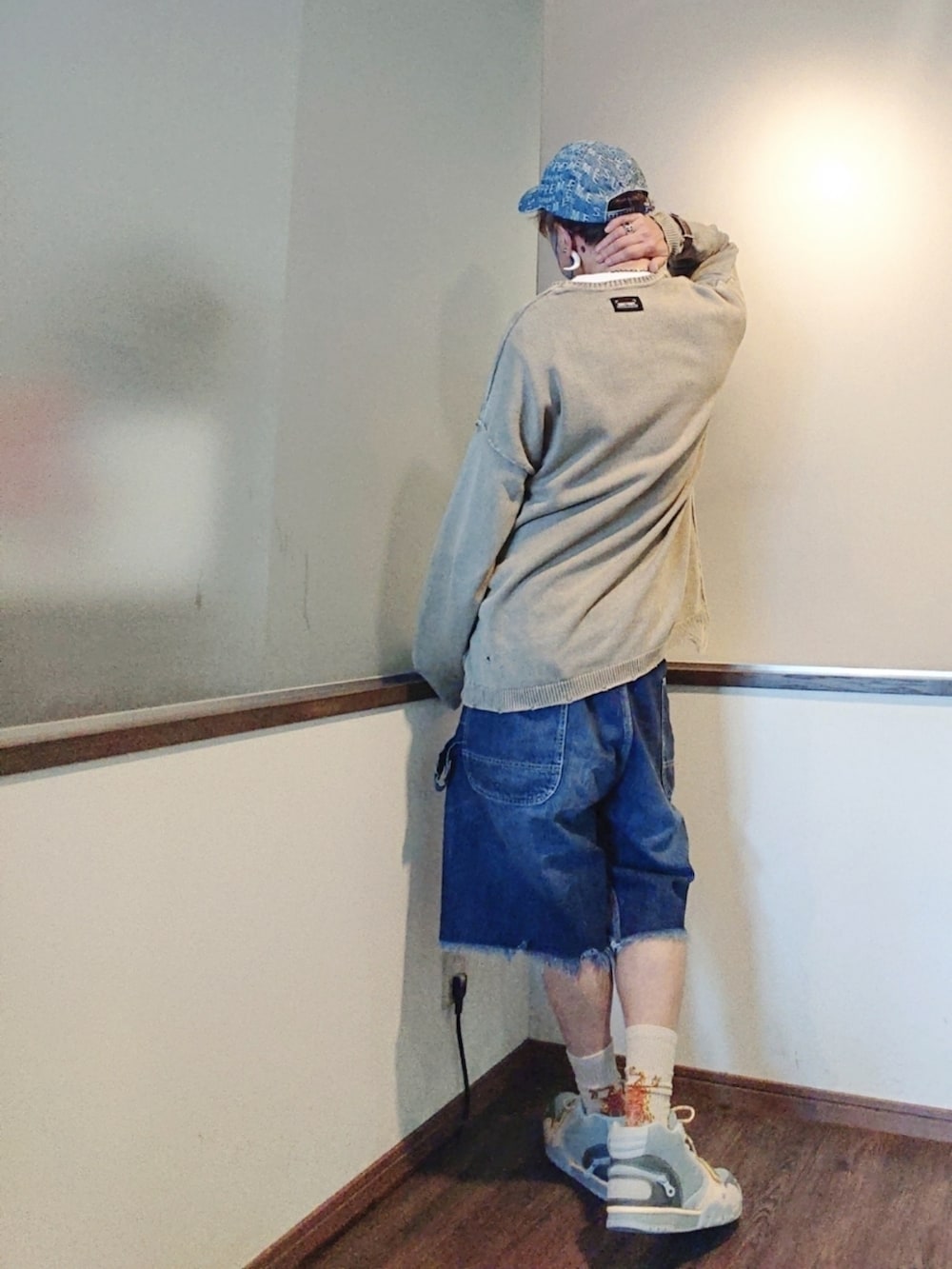 ベージュ系のニット/セーター、ブルー系のデニムパンツ、ブルー系のスニーカーを着用したメンズの夏コーディネートの2枚目の写真