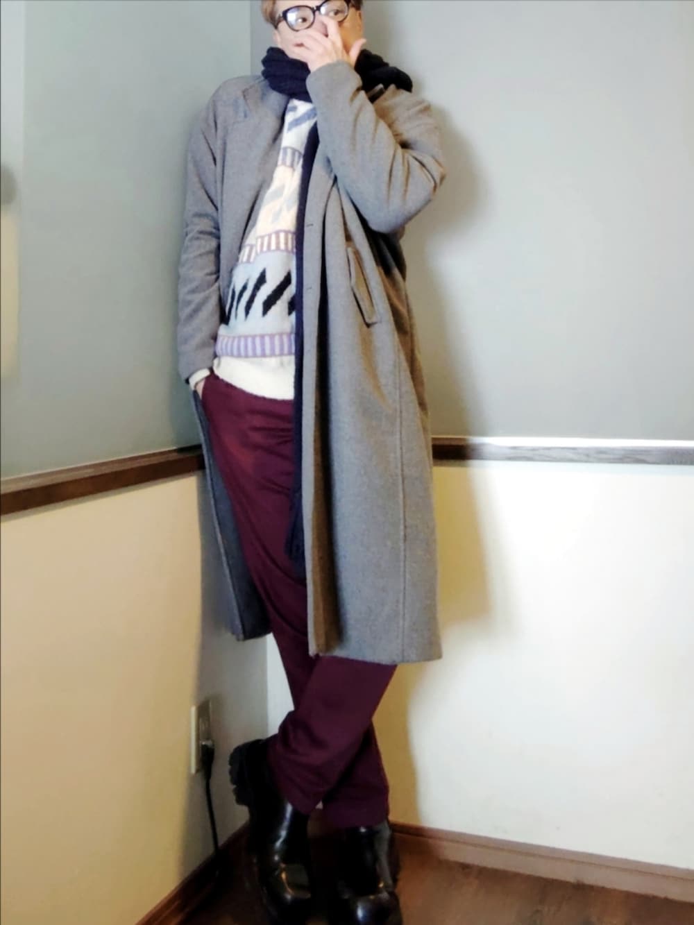 ブルー系のニット/セーター、レッド系のチノパンツ、ブラック系のブーツを着用したメンズの冬コーディネートの2枚目の写真