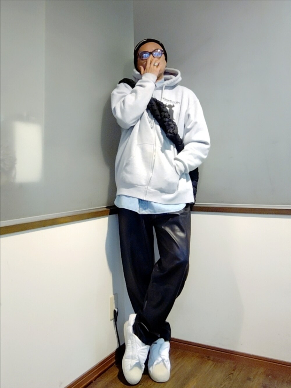 グレー系のパーカー、ブルー系のシャツ/ブラウス、ブラック系のショルダーバッグを着用したメンズの秋コーディネートの2枚目の写真