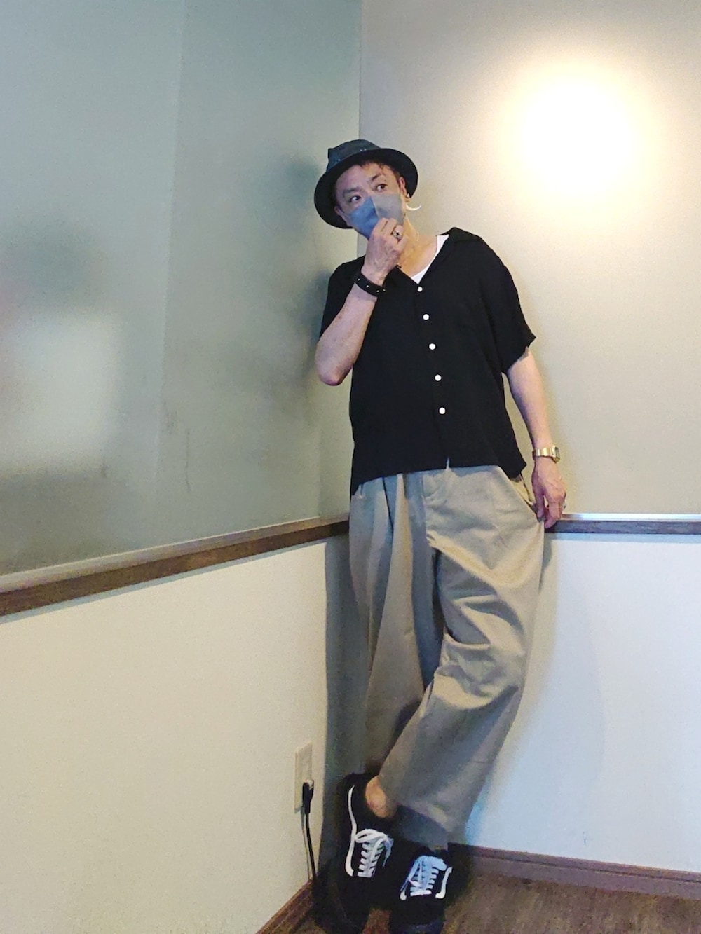 ベージュ系のチノパンツ、ブラック系のシャツ/ブラウス、ブラック系のスニーカーを着用したメンズの夏コーディネートの3枚目の写真