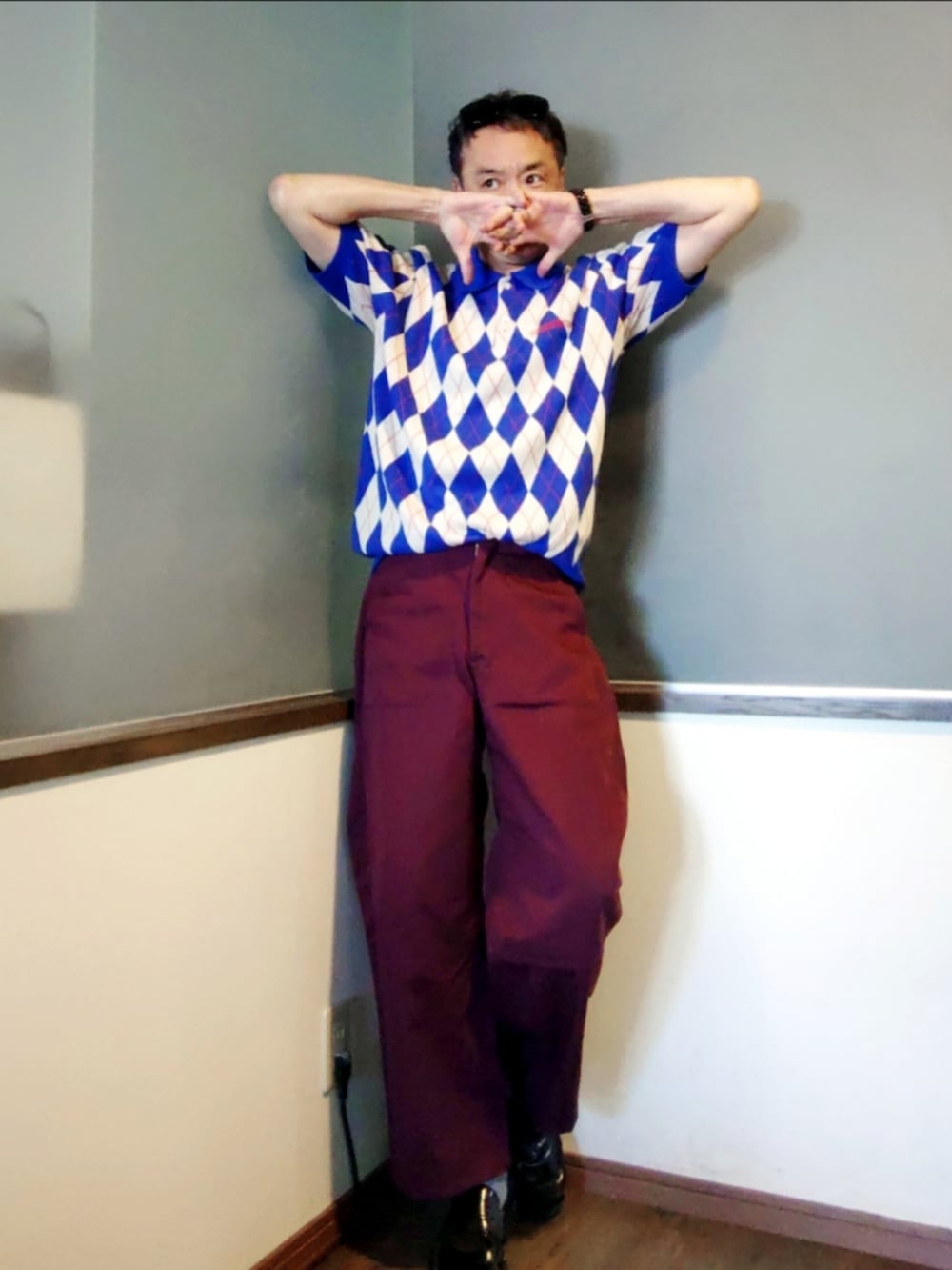 ブルー系のニット/セーター、レッド系のパンツ、ブラック系のサングラスを着用したメンズの夏コーディネートの3枚目の写真