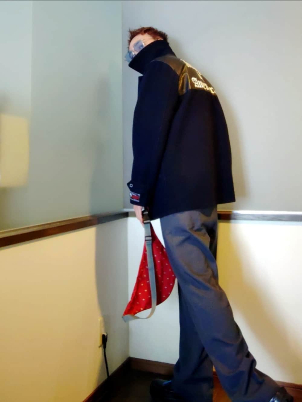 ブルー系のその他アウター、ブラック系のポロシャツ、グレー系のスラックスを着用したメンズの冬コーディネートの2枚目の写真