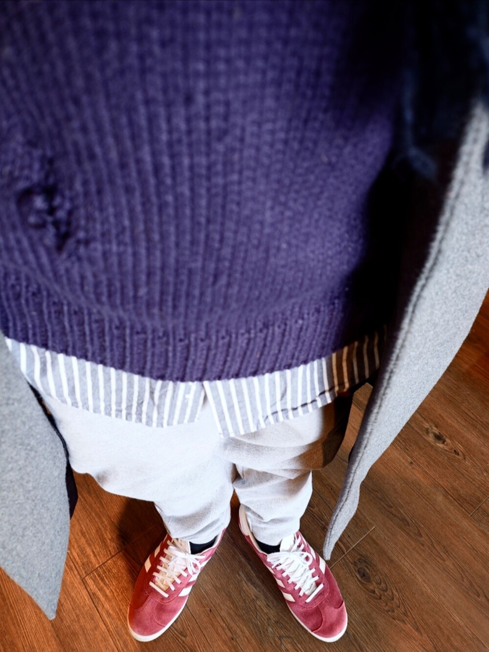 グレー系のスウェットパンツ、レッド系のスニーカー、グレー系のチェスターコートを着用したメンズの冬コーディネートの3枚目の写真