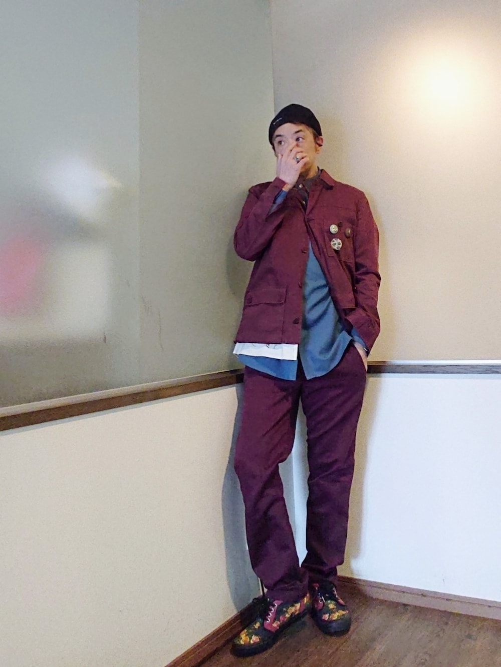 レッド系のカバーオール、ブルー系のシャツ/ブラウス、レッド系のチノパンツを着用したメンズの春コーディネートの2枚目の写真