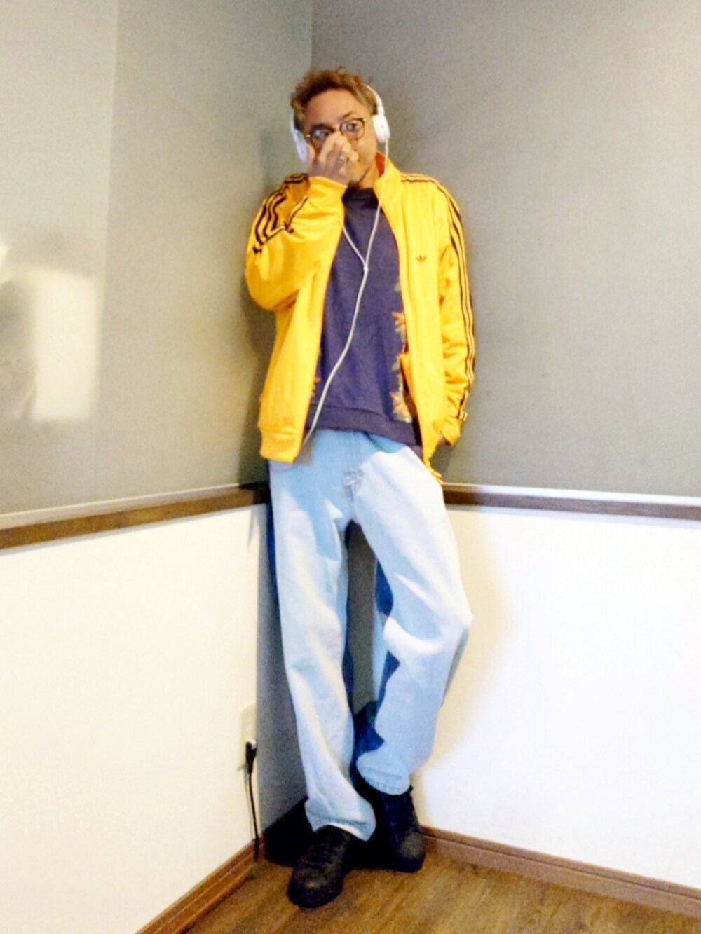 イエロー系のジャージ、ブルー系のニット/セーター、ブルー系のデニムパンツを着用したメンズの春コーディネートの2枚目の写真