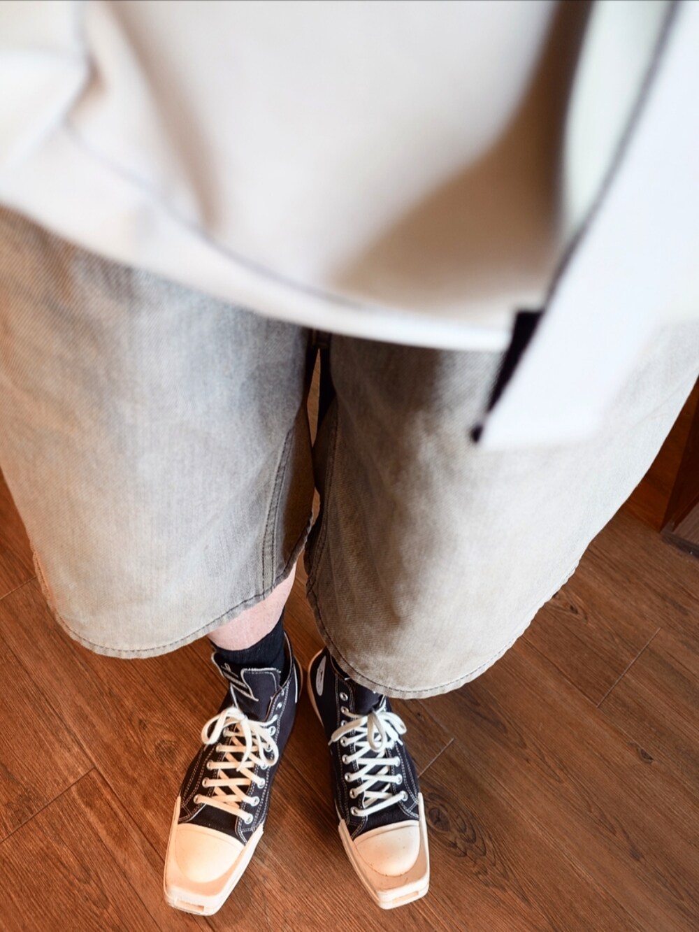 グレー系のパンツ、ホワイト系のショルダーバッグ、ブラック系のスニーカーを着用したメンズの夏コーディネートの4枚目の写真