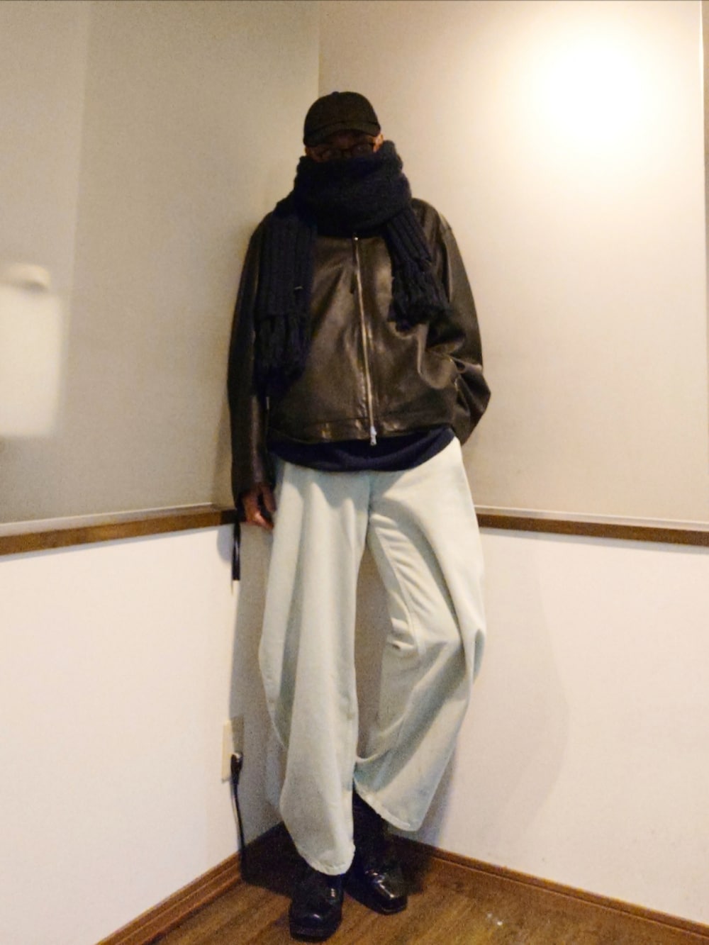 ブラック系のブルゾン、ブルー系のデニムパンツ、ブラック系のブーツを着用したメンズの秋コーディネートの3枚目の写真