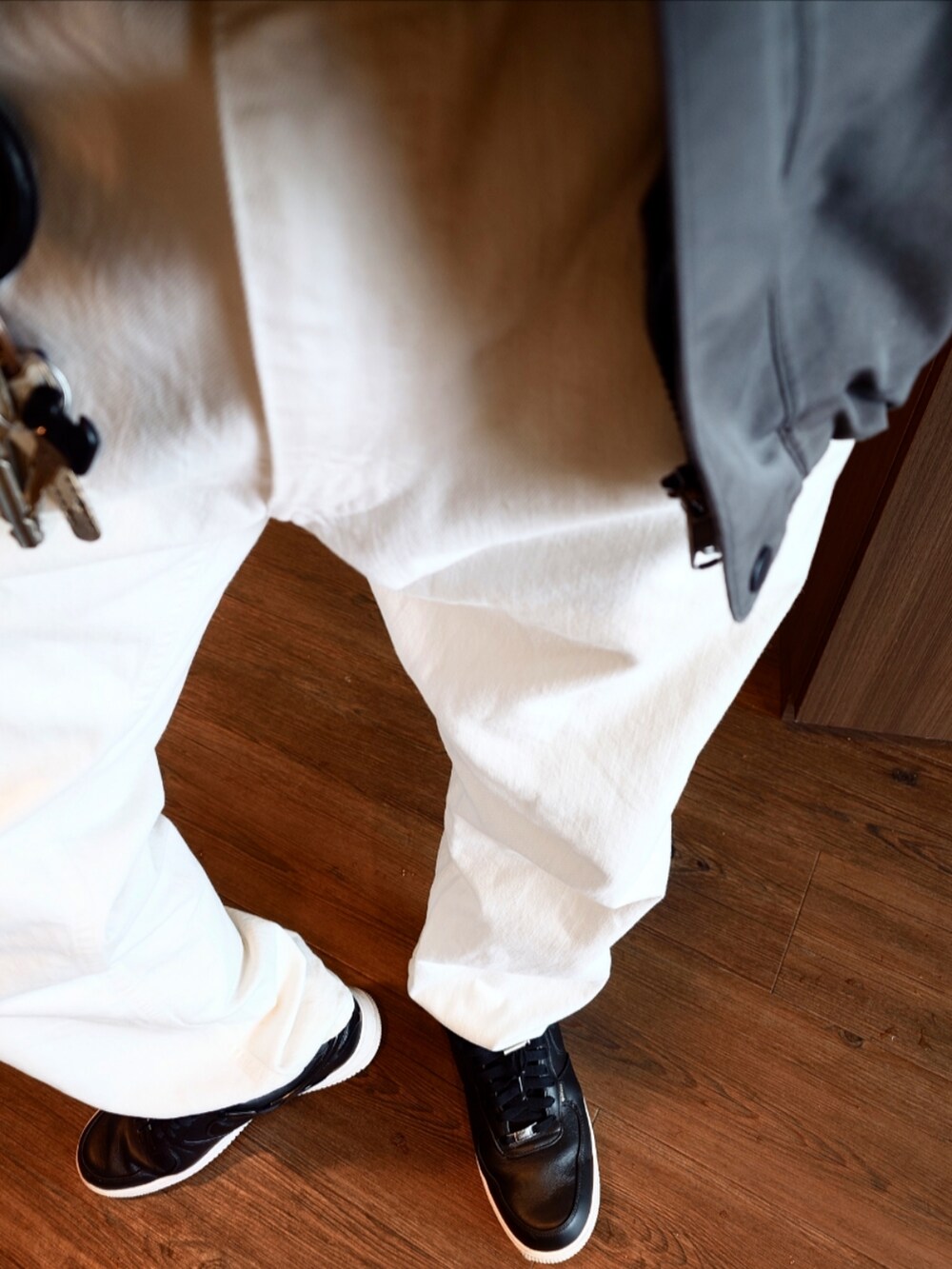 グレー系のマウンテンパーカー、グレー系のニット/セーター、ホワイト系のデニムパンツを着用したメンズの冬コーディネートの5枚目の写真