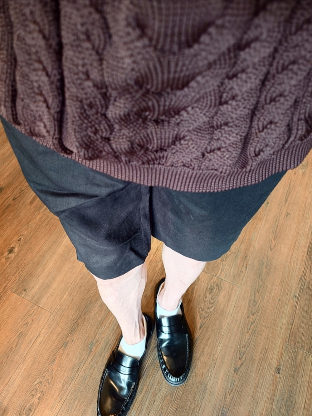 パープル系のニット/セーター、ブラック系のスラックス、グリーン系のショルダーバッグを着用したメンズの夏コーディネートの2枚目の写真