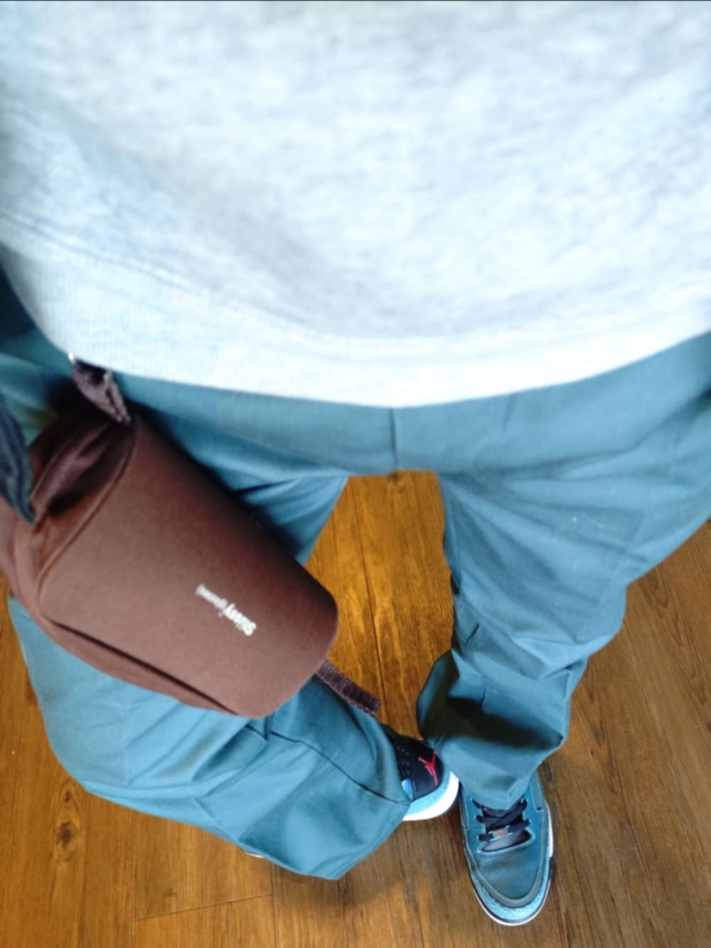 ブラック系のライダースジャケット、グレー系のパーカー、グリーン系のチノパンツを着用したメンズの秋コーディネートの2枚目の写真