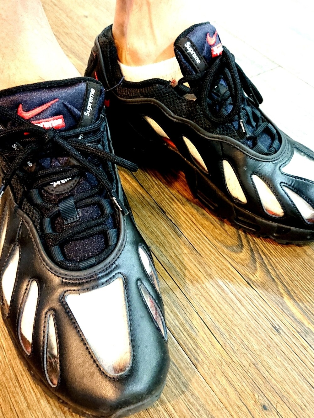 グレー系のパーカー、ブラック系のパンツ、ブラック系のスニーカーを着用したメンズの秋コーディネートの3枚目の写真